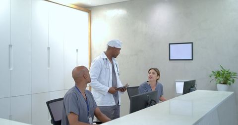 African american doctor consulting with nursing staff at modern clinic reception desk