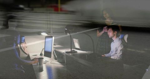 Working late with dual monitors and reflective double exposure, office collaboration