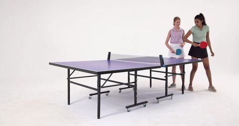Two Friends Playing Table Tennis Energetically Indoors