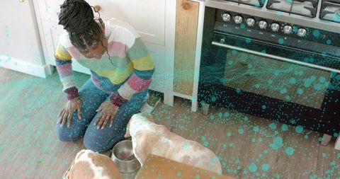 Woman Feeding Dogs in Cozy Home Kitchen