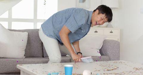 Man tidying living room after party