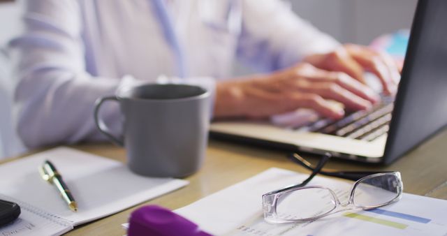 Professional Working on Laptop with Coffee Mug and Documents - Download Free Stock Images Pikwizard.com