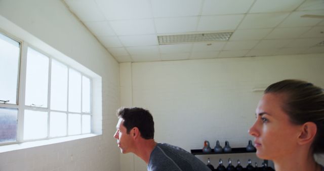 Two focused individuals in gym observing through window - Download Free Stock Images Pikwizard.com