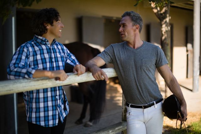Two male friends interacting with each other in the ranch on a sunny day