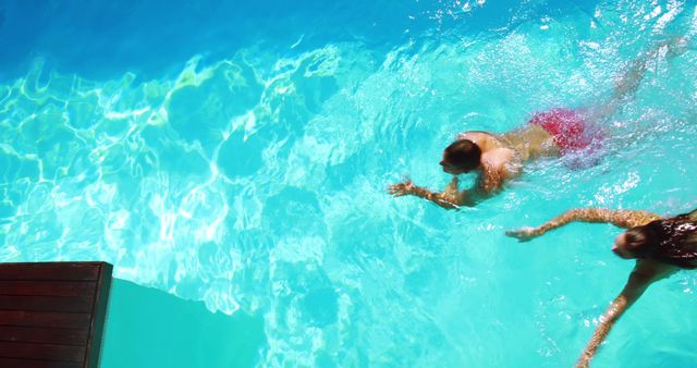 Top View of Two People Swimming in Clear Blue Pool - Download Free Stock Images Pikwizard.com