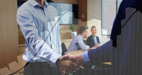 Businessmen sealing agreement with handshake in modern office