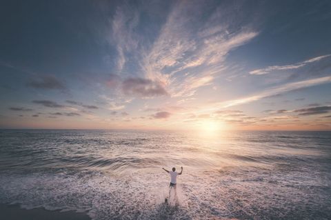 Person Enjoying Ocean Waves and Sunset