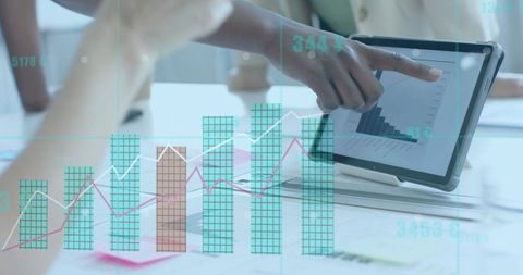 Diverse businesswomen analyzing financial growth chart on tablet