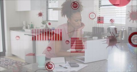 African American Woman Analyzing Data on Laptop at Home