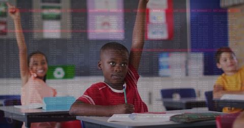 Elementary student raising hand holding pencil at classroom desk showing engagement and learning