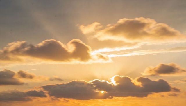 Golden Sunburst Behind Central Cloud Bank at Sunset with Dramatic Backlit Rays