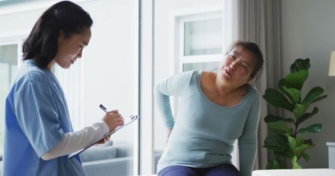 Physiotherapist Consults Patient with Back Pain in Clinic - Download Free Stock Images Pikwizard.com