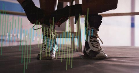 Boxer lacing boots in ring with focus and determination