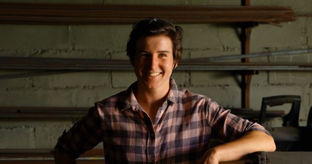 Smiling Craftsman in Workshop with Metal Pipes in Background - Download Free Stock Images Pikwizard.com