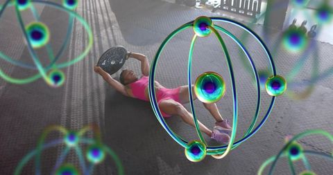 Woman performing core hold with weight plate on gym mat amid neon orb graphics