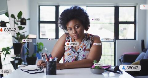 Female creator facing social notifications overload while working from home office desk