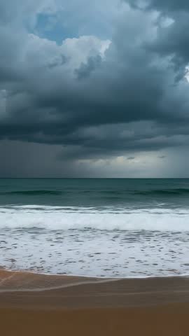 Vertical storm rolling over ocean: dark clouds gathering, waves crashing on sandy shore