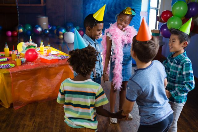 Children are enjoying a birthday party with colorful decorations, balloons, and party hats. They are playing games and having fun together. This image can be used for promoting children's events, party planning services, or birthday party supplies.