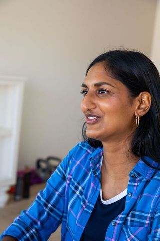 Indian Woman Sitting Casually in Home With Fitness Gear Nearby