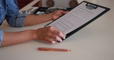 Diverse Couple Reviewing Document Together at Home Kitchen