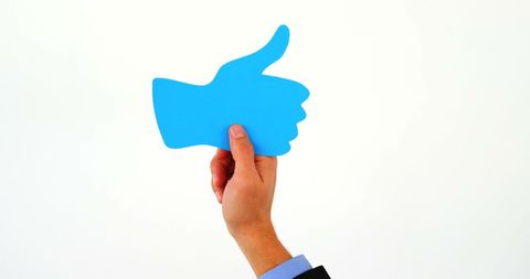 Approving thumbs up gesture in social context