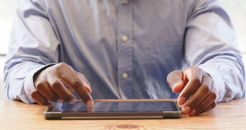 Professional Man Using Tablet for Business Tasks at Office Desk