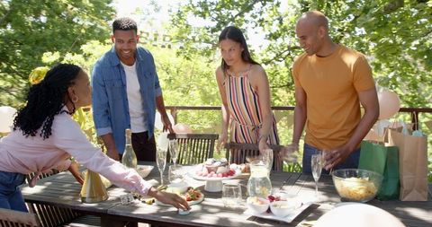 Diverse Friends Preparing Birthday Table Outdoors on Sunny Day