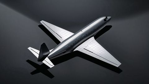 Sleek metallic aircraft model on dark surface in overhead lighting