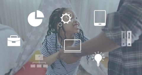 Smiling child playing with parent in bedroom teepee with floating tech icons overlay