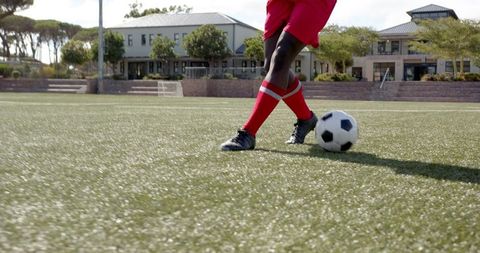 Soccer Player in Red Uniform Controlling Ball on Turf Field