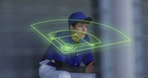 Baseball Player Analyzing Digital Game Strategy in Dugout