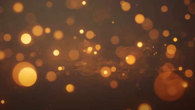 Golden bokeh orbs floating on dark amber background with warm glow and sparkles