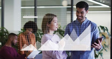 Team collaborating with tablet and data visualization overlay in modern open office