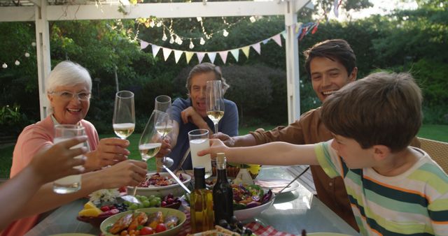 Multi-generational Family Toasting During Outdoor Garden Meal - Download Free Stock Images Pikwizard.com