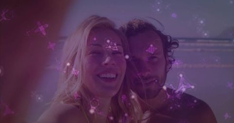 Smiling Couple on Beach with Superimposed Constellations and Waves