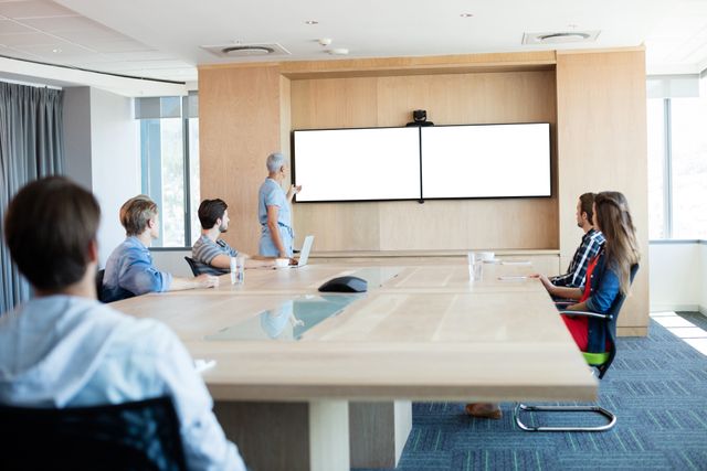 Woman giving presentation to her colleagues in conference room at office