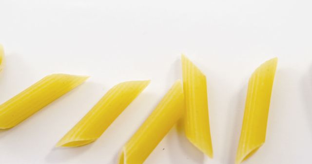 Golden Penne Pasta Pieces on White Background - Download Free Stock Images Pikwizard.com