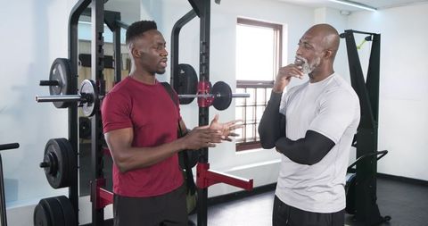African American Men Discussing Workout Form at Gym