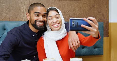 Smiling couple enjoying coffee date capturing selfie together