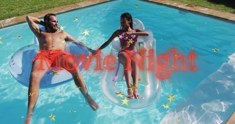 Relaxing couple holding hands on inflatable floats in backyard pool summer romance