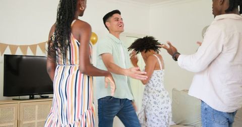 Friends Enjoying Lively Home Gathering Celebration in Casual Attire