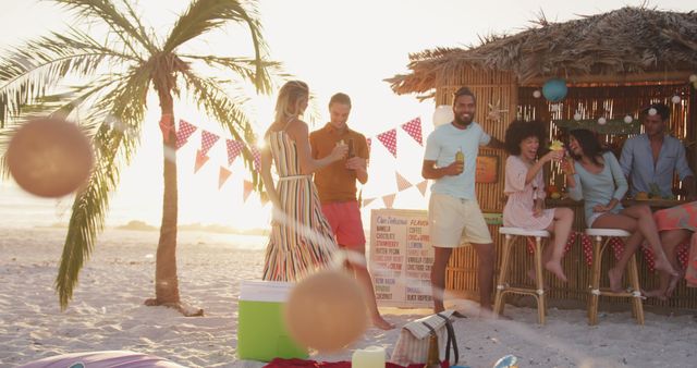 Group of young friends enjoying a lively beach party at sunset, gathered around a tiki bar with colorful decorations. Use this for summer vacation promotions, social media posts about celebrations, or travel advertisements. Captures the essence of relaxation, fun, and togetherness against a tropical backdrop.