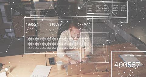 Data professional working on laptop reviewing documents with network visualization overlay