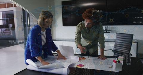 Architects Collaborating Over Blueprints in Modern Office Space