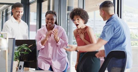 Excited colleagues engaging in office discussion