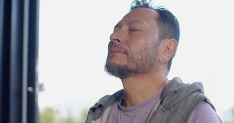 Man Practicing Meditation Near Window in Peaceful Light