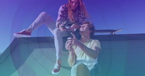 Youthful friends hanging out on skate ramp