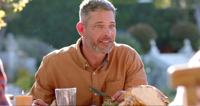 Man enjoying outdoor meal with relaxed expression - Download Free Stock Images Pikwizard.com