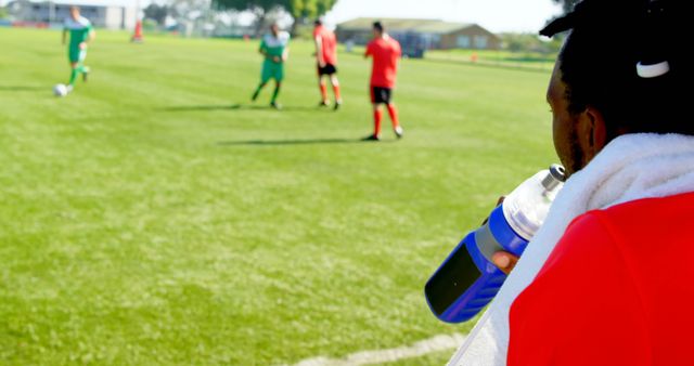 Soccer Player on Sideline Watching Match and Hydrating Unique Composition - Download Free Stock Images Pikwizard.com