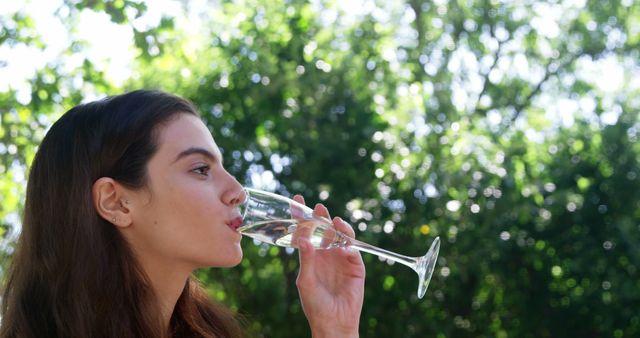 Woman drinking champagne during lunch at outdoor restaurant